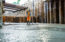 Medewerker van de aannemer maakt het gestorte beton glad.